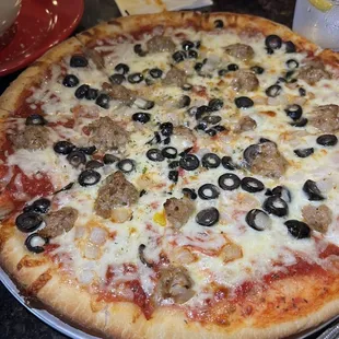 Pizza with sausage and black olives