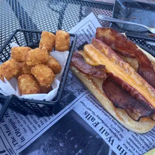Danny&apos;s dog... hot dog split with cheese in the middle and bacon, side of tots