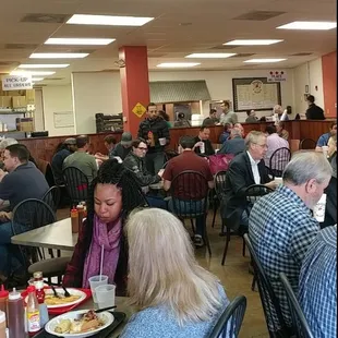 ows a large group of people eating at a restaurant