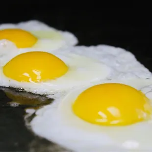 three fried eggs in a frying pan