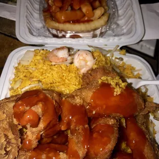a plate of fried chicken, rice, and sauce