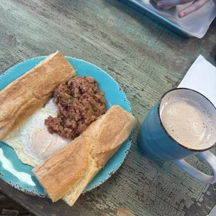 The traditional platter with 2 over easy eggs, Cuban toast, and corn beef hash. Upgraded the small cafe con leche to a medium!