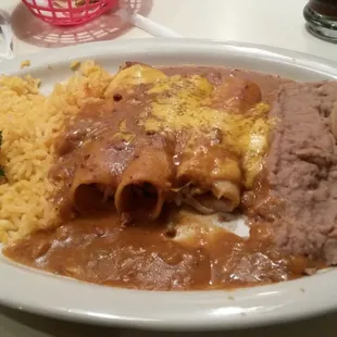 Chili con carne enchilada plate with rice and refried beans.