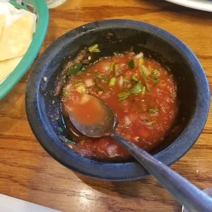 a bowl of salsa and tortillas