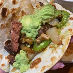 a hand holding a taco