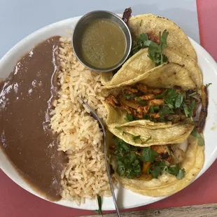Chicken tacos with the green hot sauce and el pastor (I think) on the other plate.
