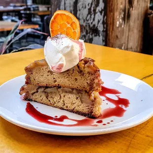 a slice of cake with ice cream and an orange slice