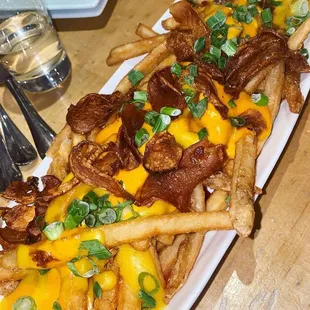 a plate of fries with cheese and bacon