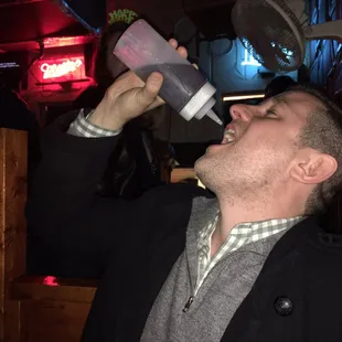 The Mayor drinking out of a squeeze container.