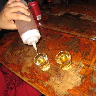 two glasses of beer and a bottle of ketchup