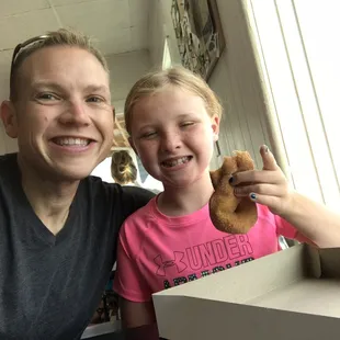 a man and a girl holding a donut