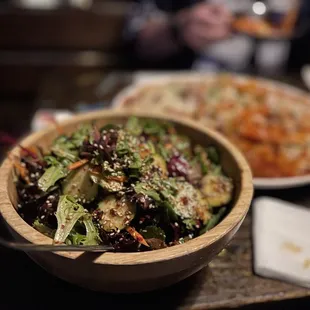 a bowl of salad and a plate of pizza