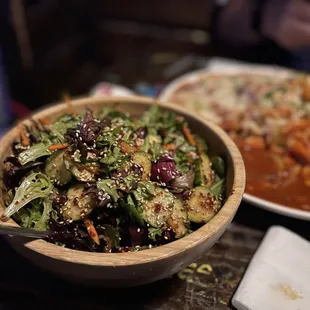 a bowl of salad and a plate of pizza