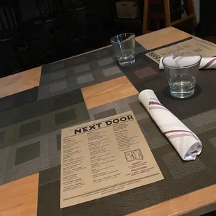 a table with a menu and a glass of water