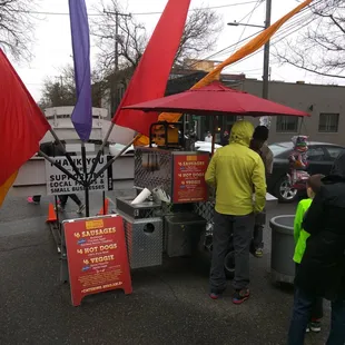 Even in the rain a line of people wait for a hot dog at Ballard&apos;s Sunday Farmers Market.