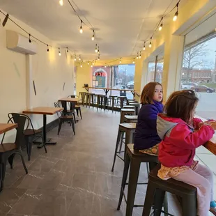 two girls sitting on stools in a restaurant