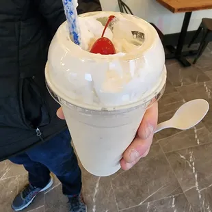 a person holding a cup of ice cream