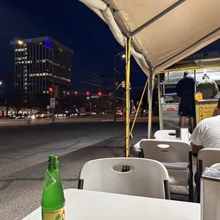 a man sitting at a table with a bottle of beer