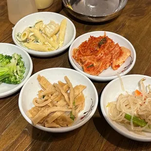 four bowls of food on a wooden table