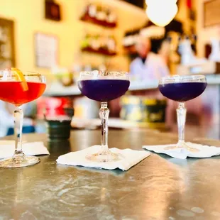 three cocktails sitting on a table