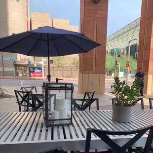 a table and chairs with an umbrella