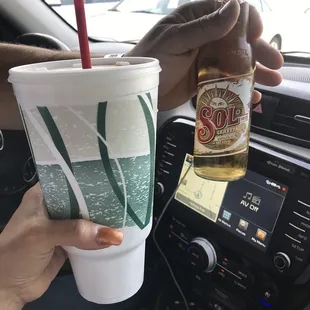 a person holding a drink in a car