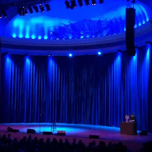 a stage with a man on a podium