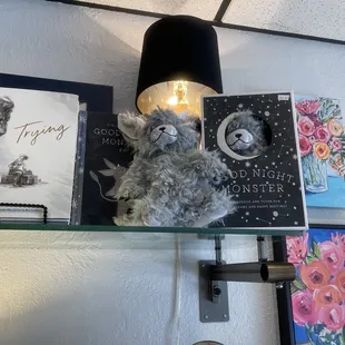 a shelf with books and a teddy bear