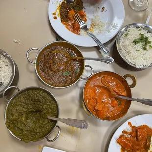 Clockwise: Basmati rice, daal makhani (variety of lentils), butter chicken, and palak paneer.