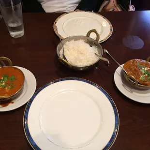 a wooden table with plates and bowls of food