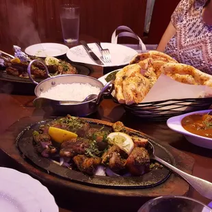a woman sitting at a table full of food