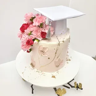 a graduation cake with pink flowers