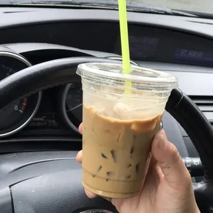 a hand holding a cup of iced coffee