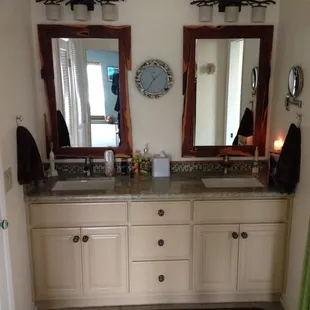 Custom vanity with rectangle under mount sinks, custom granite slab, and glass tile backsplash