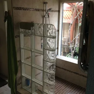 Walk in shower with garden view. Porcelain tile with four glass deco stripes.