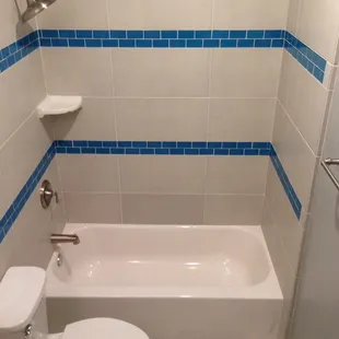 Walls 12" x 24" Porcelain Tile with Linen Print. Deco Stripes 2" x 4" Brick pattern Glass Tile. Brushed Nickel Fixtures.