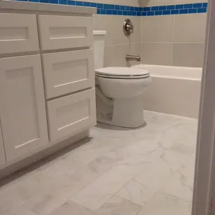 Porcelain 6x24 Tile. Custom built Shaker Style Cabinet. New Toilet and Tub.
