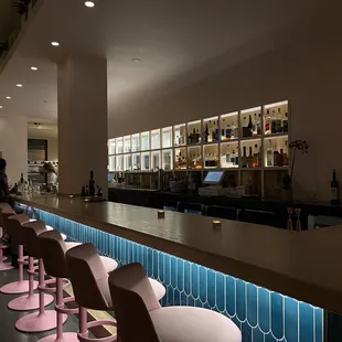 a row of pink stools at a bar