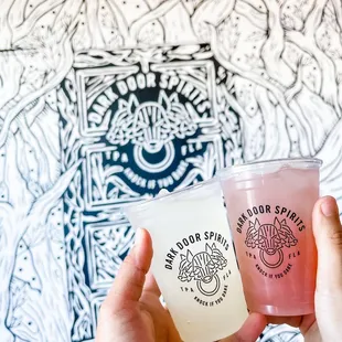 two people holding drinks in their hands