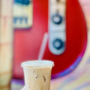 a hand holding a cup of iced coffee