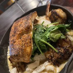 Salmon seafood platter on bed of Spinich and rice in creole sauce