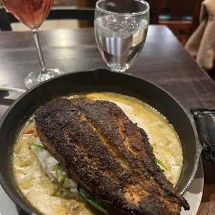 Blackened catfish in creole sauce on a bed of spinach and rice
