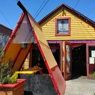 a small yellow building with a red roof