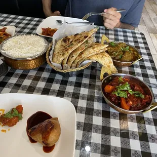 White rice, samosas on plate in foreground, a chicken appetizer far left... forgot which one.