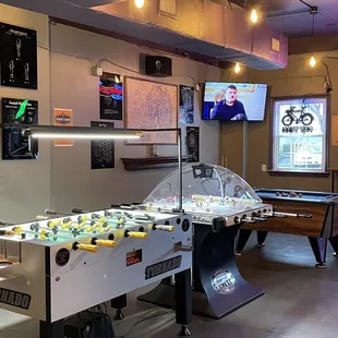 a game room with a billiard machine and a pool table