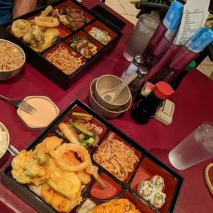 2 bento boxes, one was salmon the other one was beef both with noodles, teriyaki vegetables plenty of tempura vegetable and 4 pc of sushi,