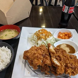 a plate of fried chicken, rice, and vegetables