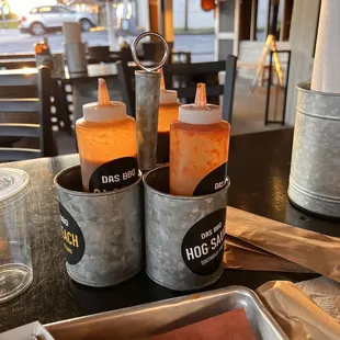 two bottles of hot sauce on a table