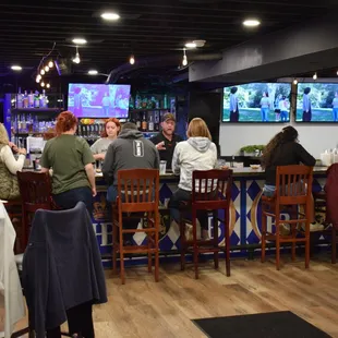 a group of people sitting at a bar