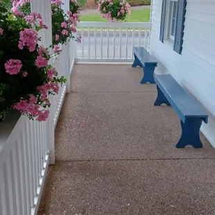 a porch with a bench and flowers